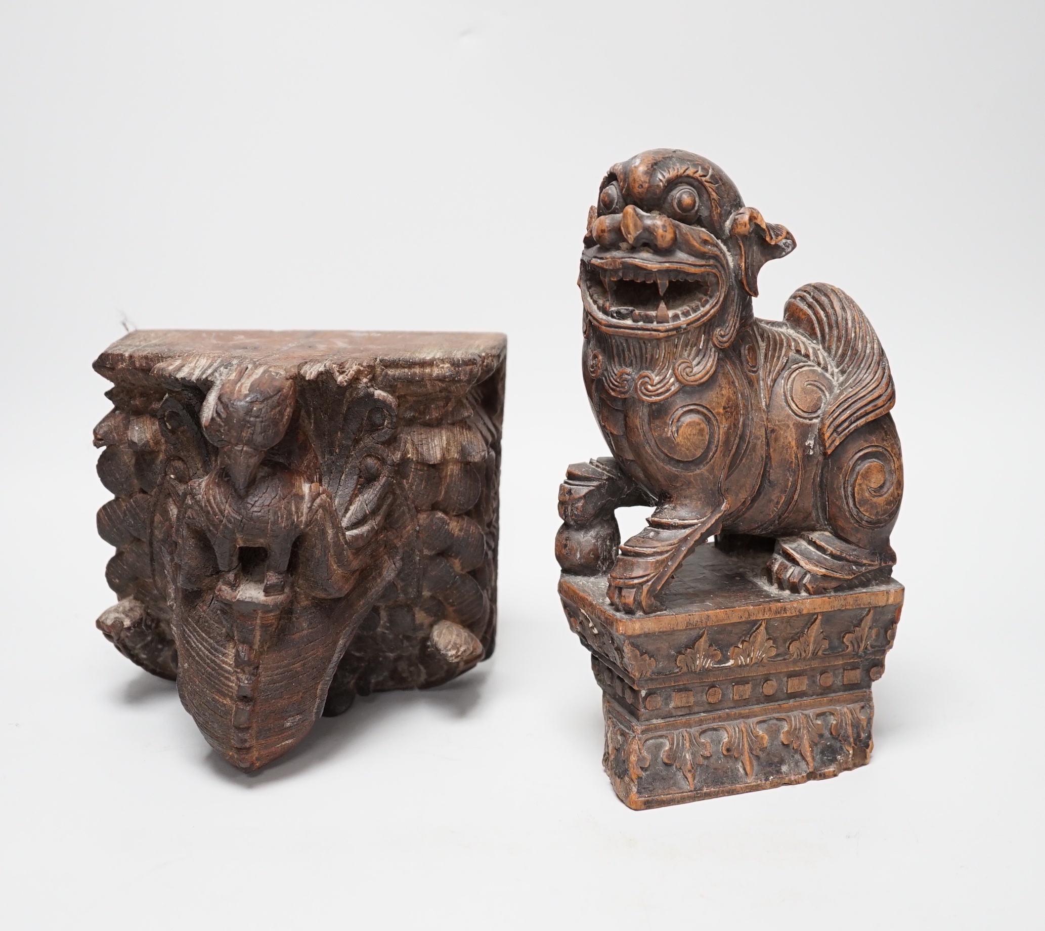 A carved South East Asian hardwood temple lion and an Indian wall bracket (2) tallest 23cm